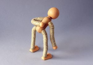 Man die voorzichtig zijn rug aanraakt met beide handen, illustreert het thema sneller van rugpijn afkomen